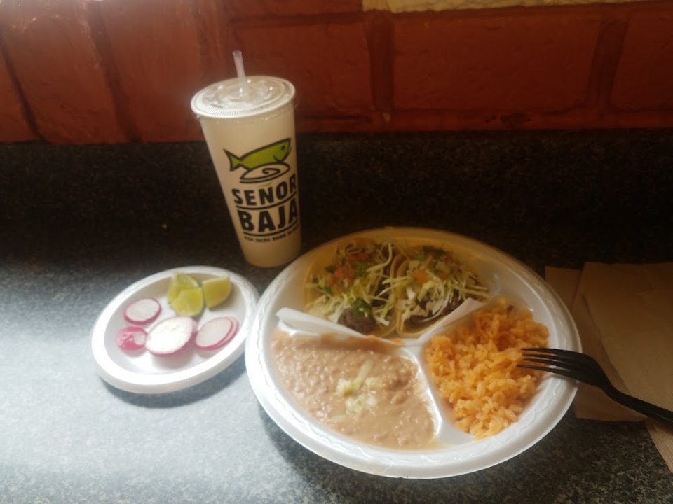 Printed menu showing fish tacos and shrimp burritos.