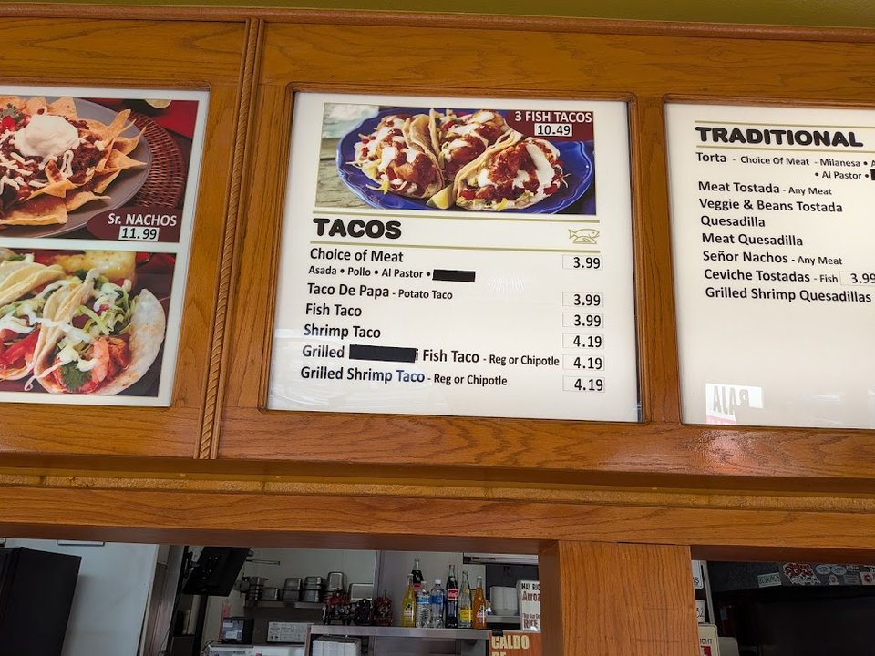 Menu board with tacos, burritos, and breakfast plates.